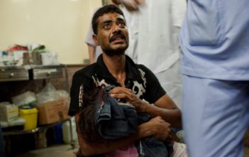 A father carries his wounded daughter to get medical help in Aleppo, Syria