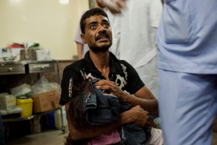 A father carries his wounded daughter to get medical help in Aleppo, Syria