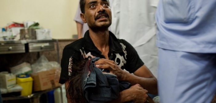 A father carries his wounded daughter to get medical help in Aleppo, Syria