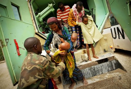 A Somali woman hands her severely malnourished child to an African Union medical officer