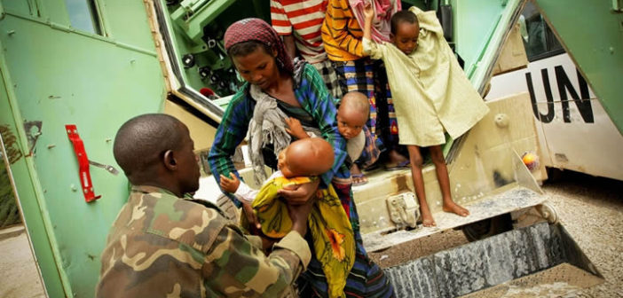 A Somali woman hands her severely malnourished child to an African Union medical officer