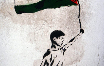 Graffiti of boy holding Palestinian flag