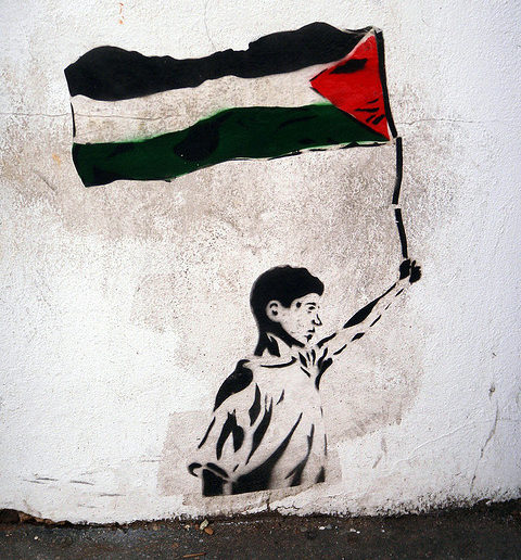Graffiti of boy holding Palestinian flag