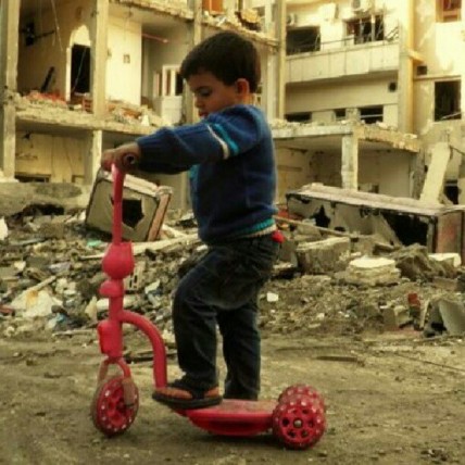 A child plays on a destroyed street in Homs, Syria
