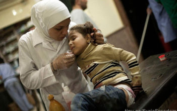 A nurse cares for an injured girl in Syria after her house was bombarded in an attack