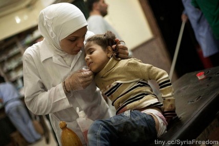 A nurse cares for an injured girl in Syria after her house was bombarded in an attack