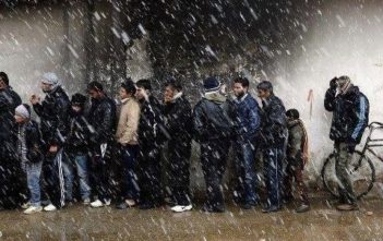 People queue for bread as the snow falls in Damascus.