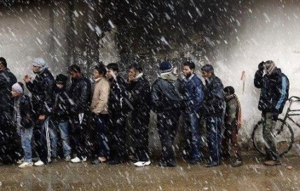 People queue for bread as the snow falls in Damascus.