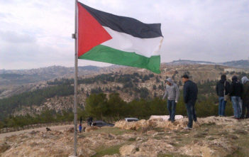The Palestinian flag flies over Bab Al Shams