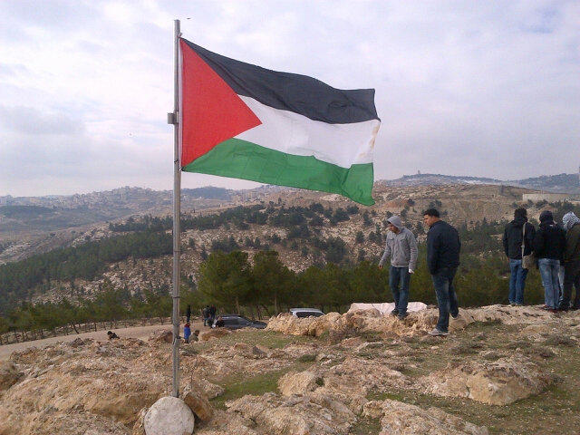 The Palestinian flag flies over Bab Al Shams