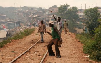 Rowdy youth throw stones in Kibera slums, Nairobi; Kenya