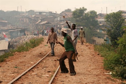 Rowdy youth throw stones  in Kibera slums, Nairobi; Kenya
