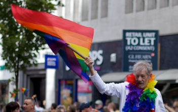 Sir Ian McKellen waves multicoloured flag of gay rights