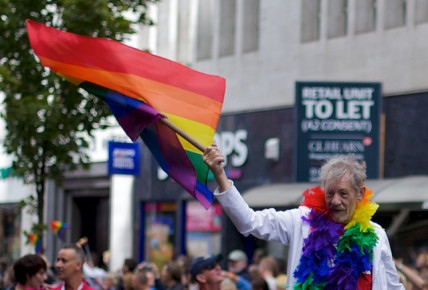 Sir Ian McKellen waves multicoloured flag of gay rights
