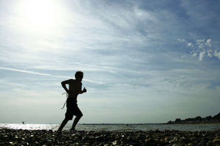Man runs along a pebble beach