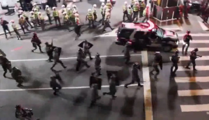 Riot police rushing towards peaceful protesters chanting "no violence"