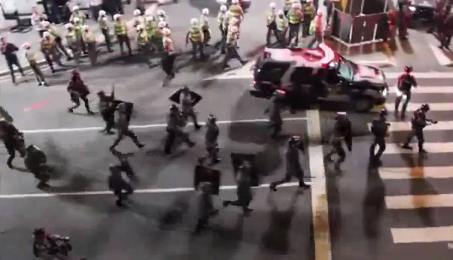 Riot police rushing towards peaceful protesters chanting "no violence"
