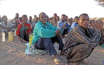 Migrants queue before being smuggled from Obock, Djibouti to Yemen