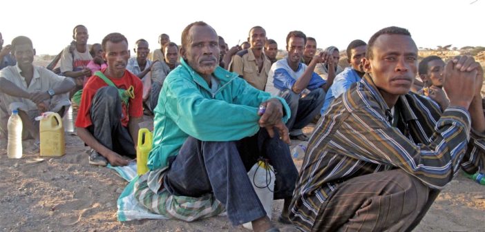 Migrants queue before being smuggled from Obock, Djibouti to Yemen