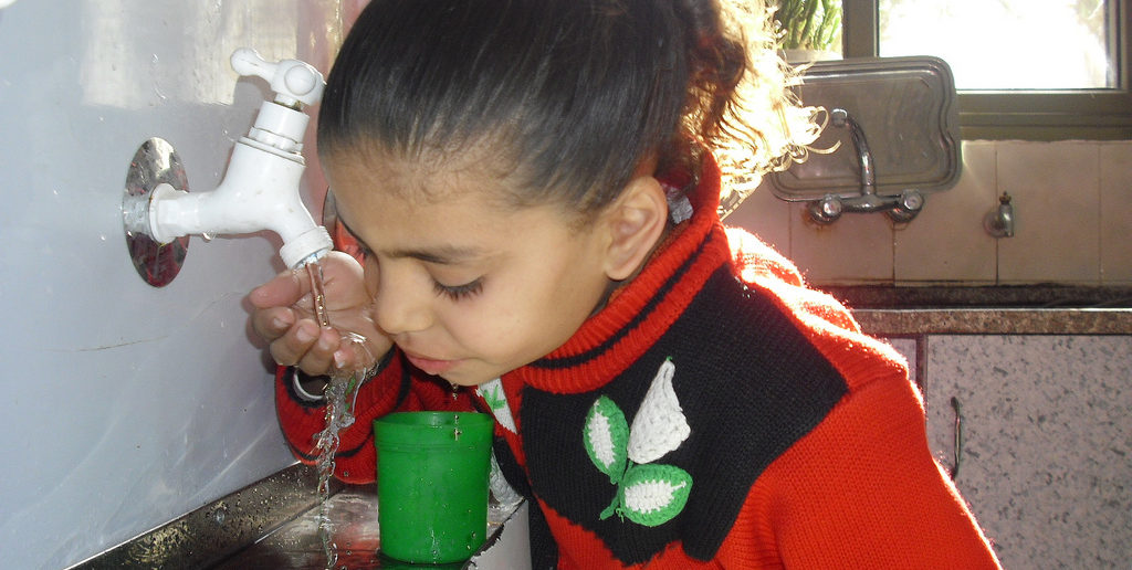 Child drinks water in Gaza