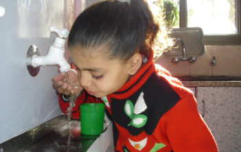 Child drinks water in Gaza