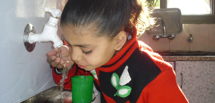 Child drinks water in Gaza